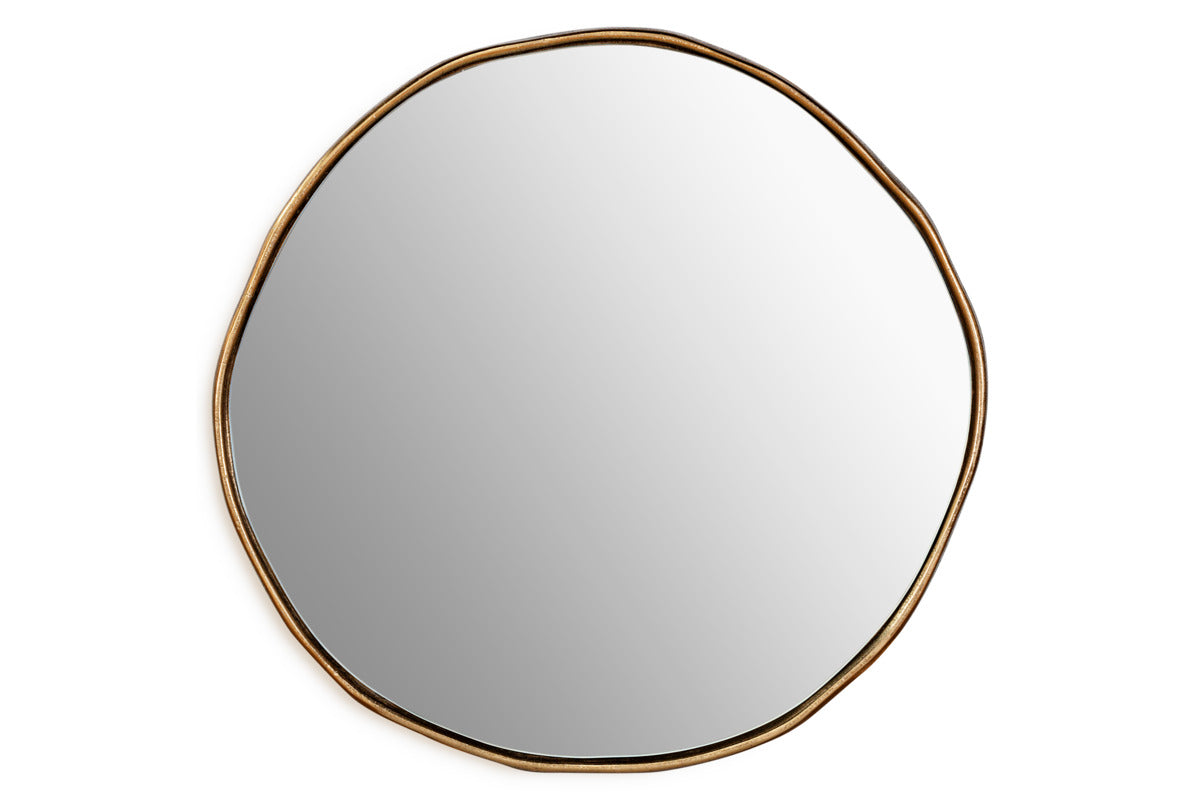 The nkuku Mchanga Organic Shape Mirror features a round, irregular shape with a thin antique brass frame. Its smooth, clear surface and minimalist design give this wall mirror a modern artistic look against a plain white background.