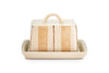 The Patthar Butter Dish - Cream & Clay by nkuku is hand-painted with vertical beige stripes and dotted accents. It features a curved handle, a fitted lid, and sits on a matching cream tray. Shown on a plain white background.