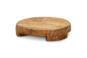 The Kaveeta Board - Natural by nkuku is a round, rustic wooden pedestal with three short legs, crafted from reclaimed wood. Its unpolished surface showcases natural grain and timeworn details. Photographed on a white background.
