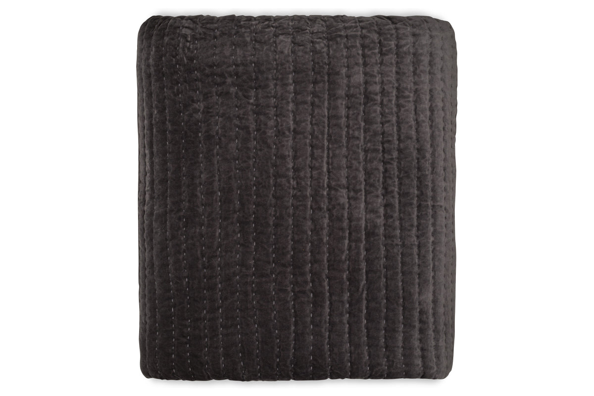 The Nidra Velvet & Linen Bed Quilt - Charcoal by nkuku is a folded, dark gray cotton velvet and linen quilt with vertical Kantha stitching, shown against a white background. Suitable for King and Super King beds.