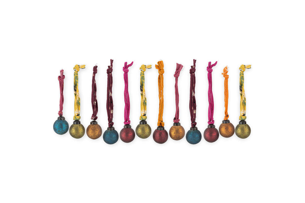 The nkuku Oko Mini Baubles - Mixed Matt (Set of 12) features metallic blue, red, gold, and brown baubles with a rustic matte finish and vibrant hanging ribbons, arranged in a charming festive row against a white background.