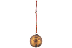 The nkuku Oko Giant Bauble in matt gold is an oversized, metallic oval ornament with a tarnished finish. It hangs from a red and orange string by a small loop, ideal for festive décor, and is shown against a plain white background.