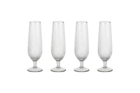 The Otuba Champagne Flute - Clear (Set of 4) by nkuku features four ribbed, recycled glass flutes arranged in a row on a white background.