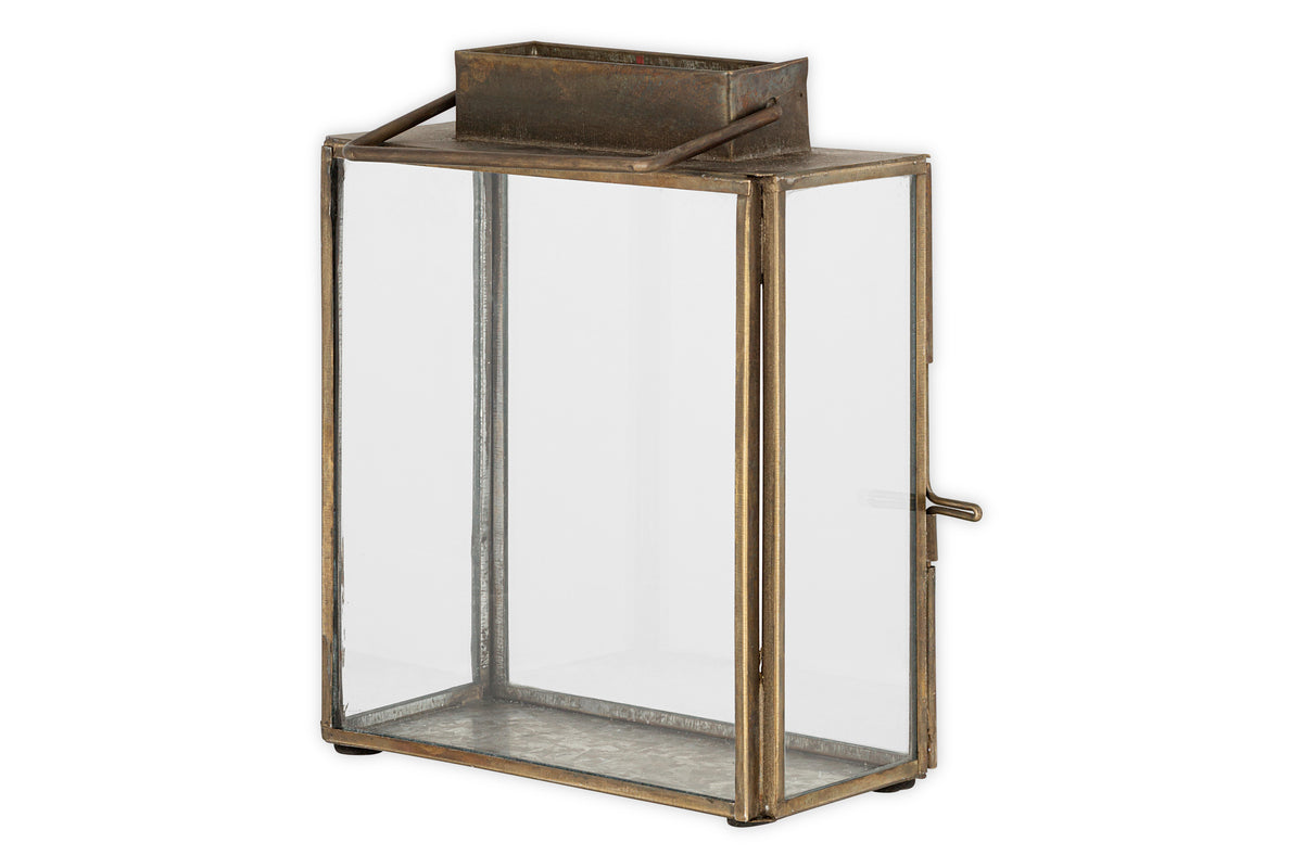 The nkuku Obi Mini Table Lantern in Antique Brass features a rectangular metal frame, clear glass panels, open top, small side handle, and a rustic finish—perfect for adding vintage candlelight ambiance to your space.