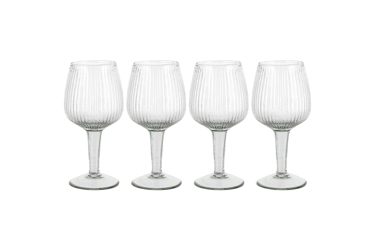 The Otuba Wine Glass - Clear (Set of 4) from nkuku features four recycled glass wine glasses with vertical ribbing, displayed in a row against a white background.