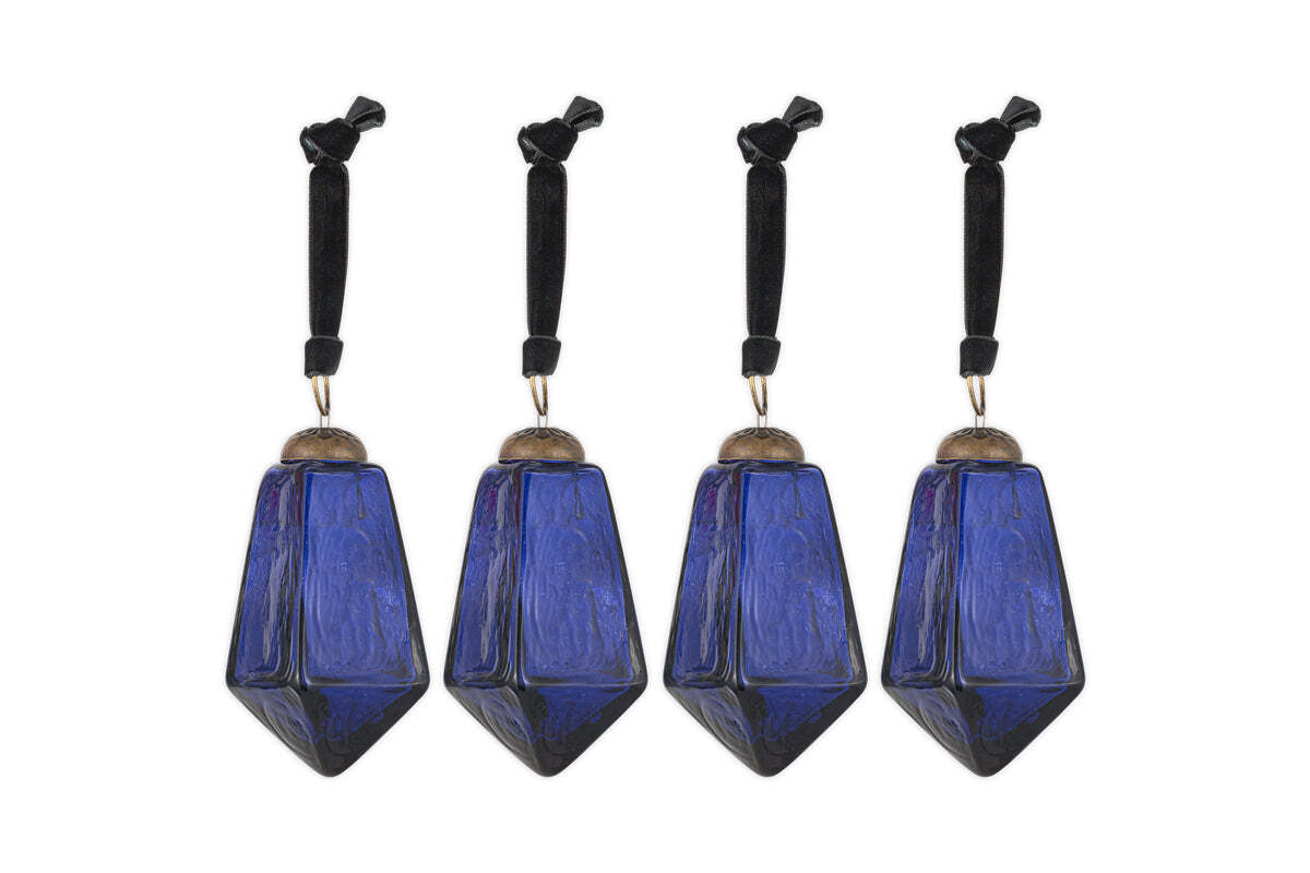 The nkuku Ratnam Baubles - Indigo - Large (Set of 4) feature geometric, faceted deep blue glass with an antique finish, textured surfaces, silver-colored caps, and black cords—bringing classic elegance to your holiday decor.