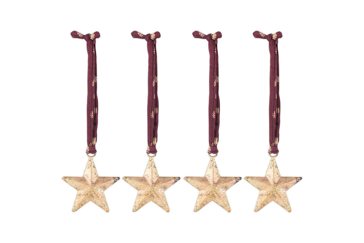 The Roshani Star Baubles - Antique Brass (Set of 4) by nkuku feature sleek gold star silhouettes with an antique brass finish and red string for hanging.