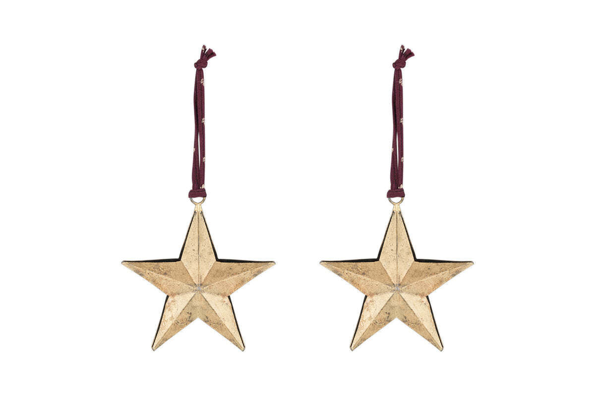 The nkuku Roshani Star Baubles - Antique Brass (Set of 2) feature five-pointed gold stars with a textured finish, hanging from burgundy ribbons and perfect for festive decor.