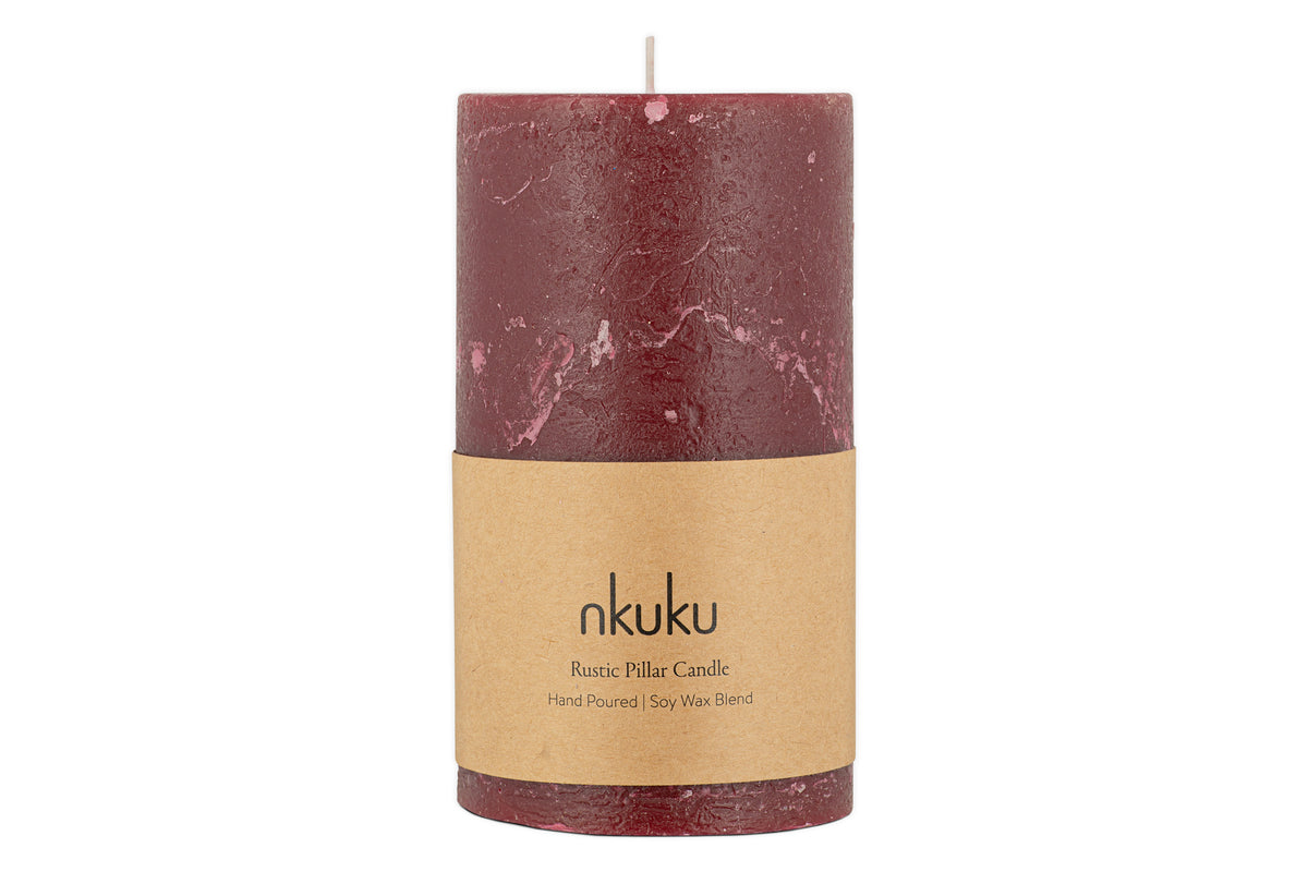 The nkuku Rustic Soy Blend Pillar Candle - Dark Cherry - Large features a beautifully textured finish and a brown paper label reading nkuku Rustic Pillar Candle Hand Poured | Soy Wax Blend.