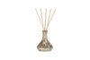 The nkuku Juniper & Fir Reed Diffuser features a decorative glass bottle with a metallic finish, filled with bespoke fragrance oil and six natural reeds fanning from the neck, displayed against a white background.