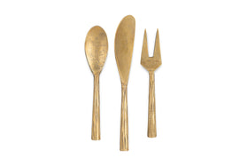 The nkuku Roda Serving Set - Antique Brass (Set of 3) includes a spoon, long knife, and two-pronged fork arranged vertically on a white background—ideal antique brass cheese and charcuterie serving utensils.