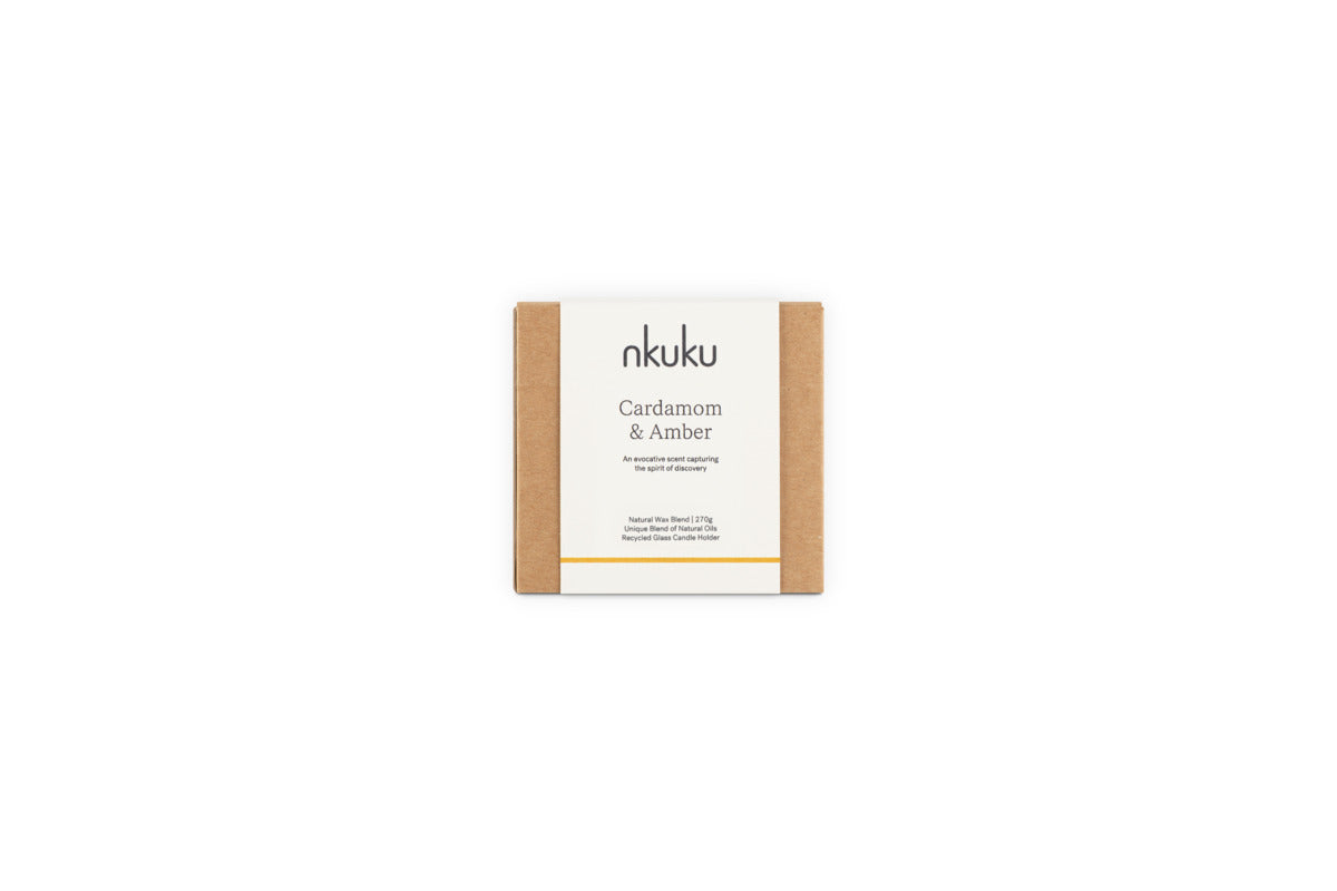 A Cardamom & Amber 1 Wick Scented Candle by nkuku in minimalist brown packaging, featuring sandalwood notes. The natural blend and handcrafted design evoke warmth and comfort.