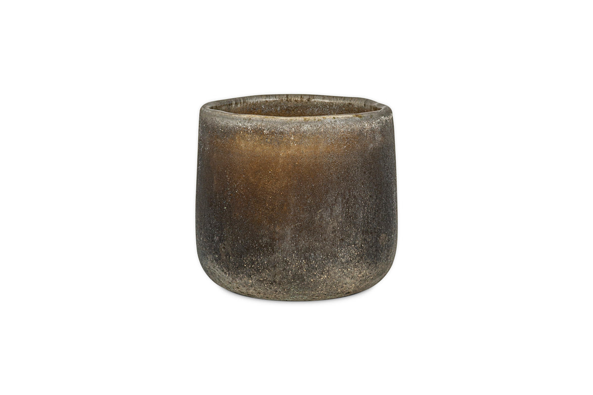 The nkuku Cedarwood & Fig 1 Wick Scented Candle is housed in a round, textured dark brown ceramic pot with a matte finish and slightly uneven rim, displayed against a white background.