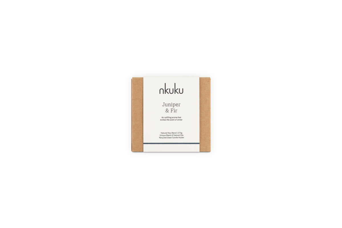 A small square box with a minimalist nkuku Juniper & Fir label in black on white holds the Juniper & Fir 1 Wick Scented Candle, offering elegant, sustainable reuse in its vessel.