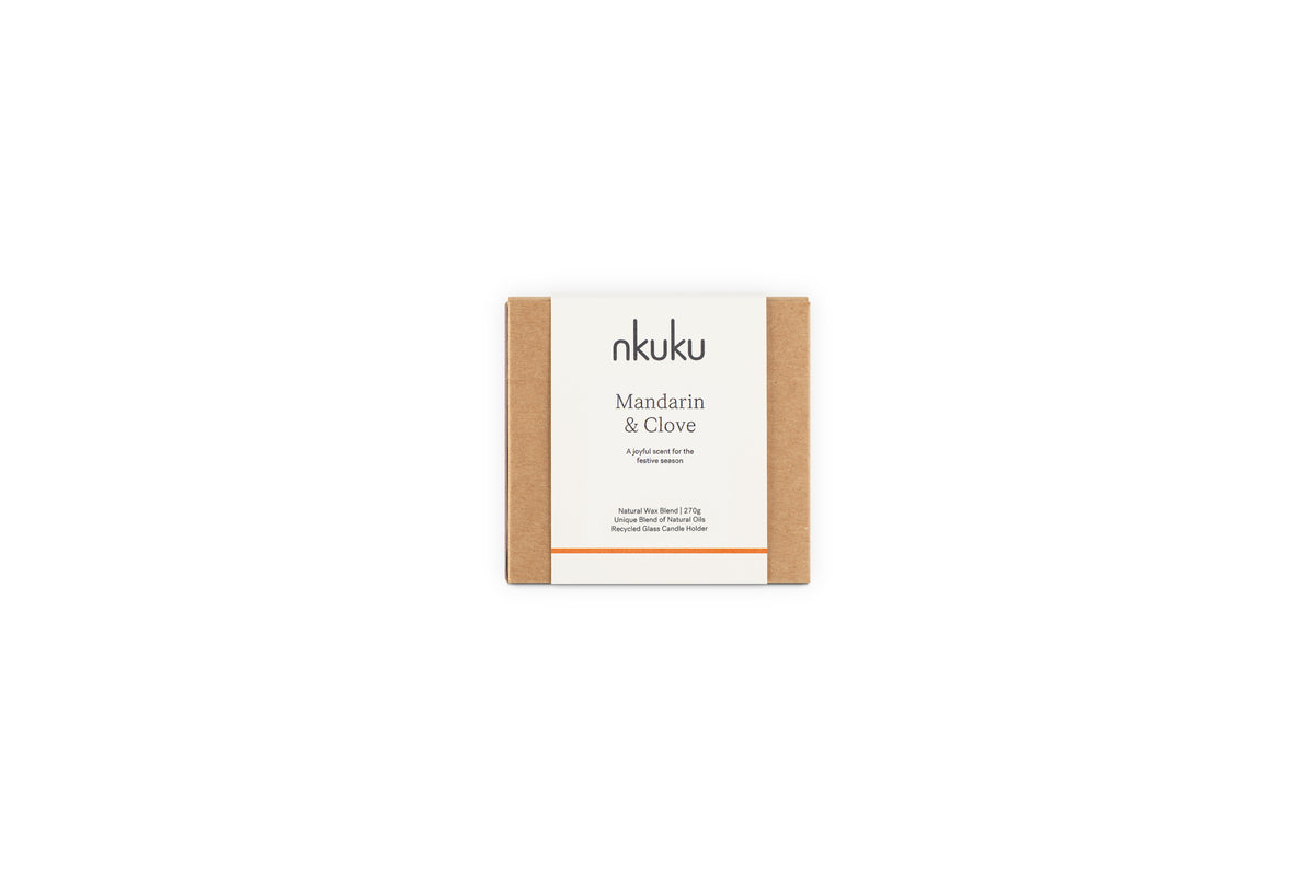A square brown cardboard box with a white nkuku label holds the Mandarin & Clove 1 Wick Scented Candle, evoking a festive spiced mandarin fragrance, set against a plain white background.