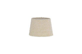 The Sakiti Bouclé Lampshade by nkuku features an off white, textured design with a gently tapered cylindrical shape. Crafted from cozy bouclé material, it adds ambient lighting to any space. The product image has a plain white background.