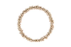 The nkuku Tanu Mango Wood Beaded Wreath in Brass & Natural features small, light-colored beads and antique brass wire in a clustered, circular design with a natural, textured look against a plain white background.
