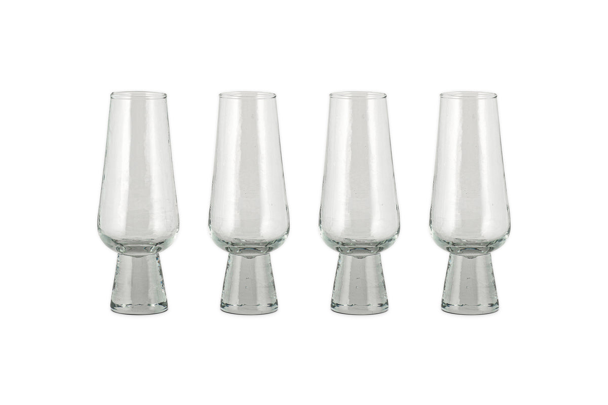 A set of four nkuku Visla Champagne Flutes in clear, hand-blown glass with wide, sturdy bases is arranged in a row on a white background.