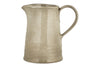 The nkuku Valinha Earthenware Jug in Grey (Large) features a wide body, narrow spout, and a large right-side handle, offering elevated serveware to enhance your dining experience. Shown against a white background.