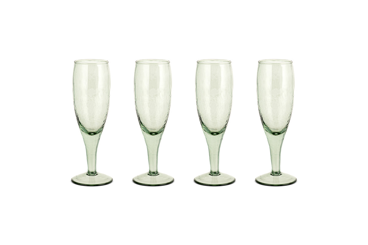 The nkuku Yala Hammered Champagne Glasses (Set of 4) in sage green feature textured, hammered glass and are shown side by side on a white background.
