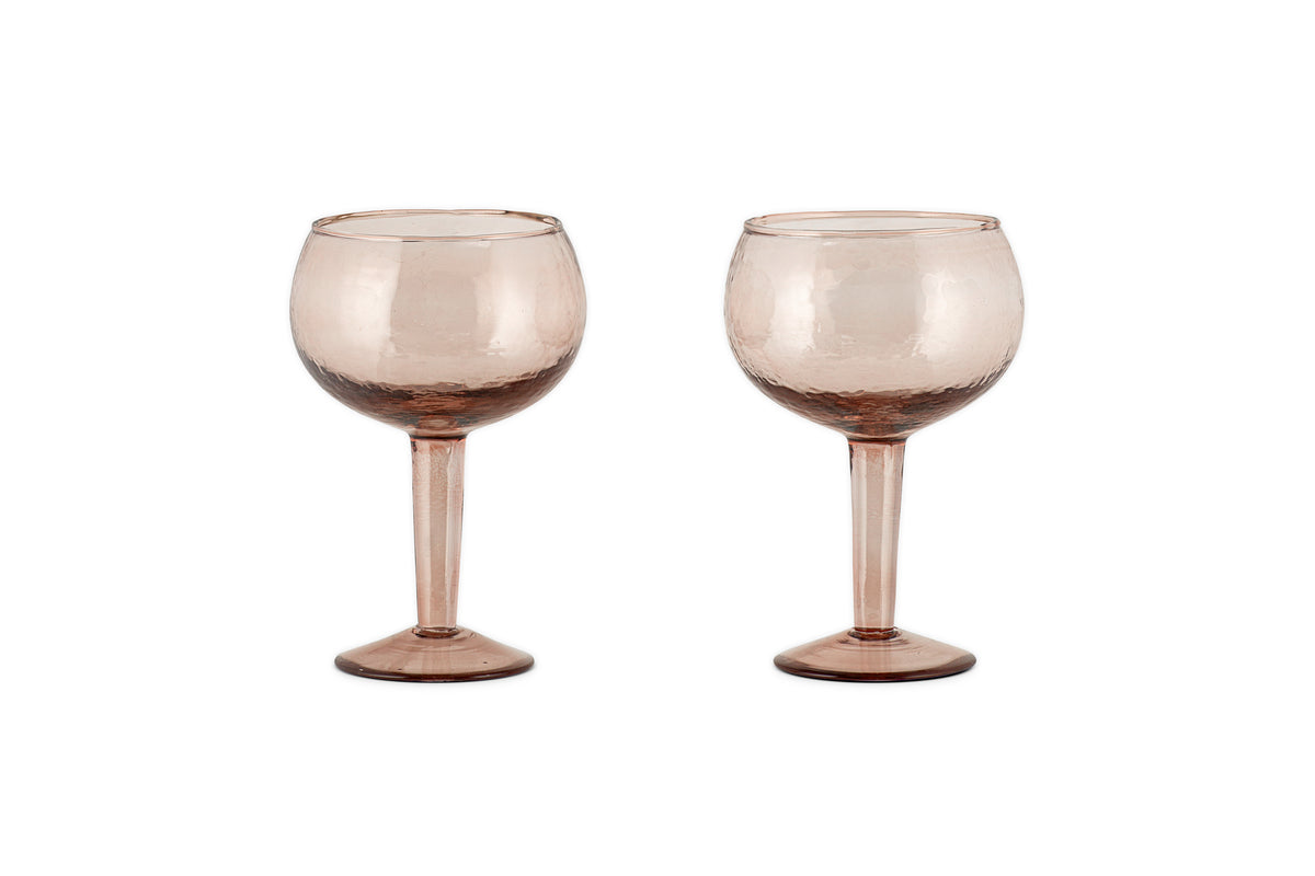 Two Yala Hammered Gin Glasses in Dusty Terracotta by nkuku, featuring textured, round bowls and elegant hammered detailing, are displayed side by side on a white background. Set includes 2 glasses.