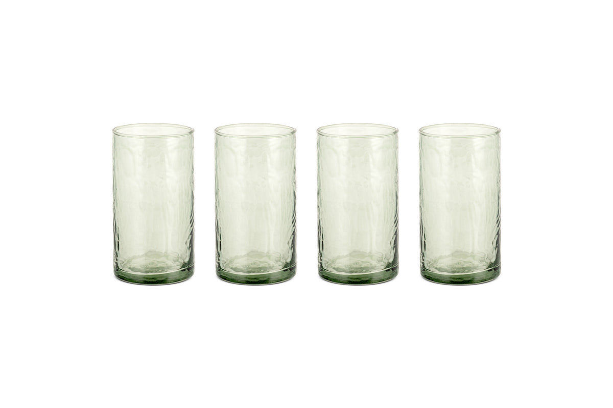 Four Yala Hammered Highball glasses in sage green by nkuku are arranged in a row on a white background. This set includes four cylindrical cocktail glasses.