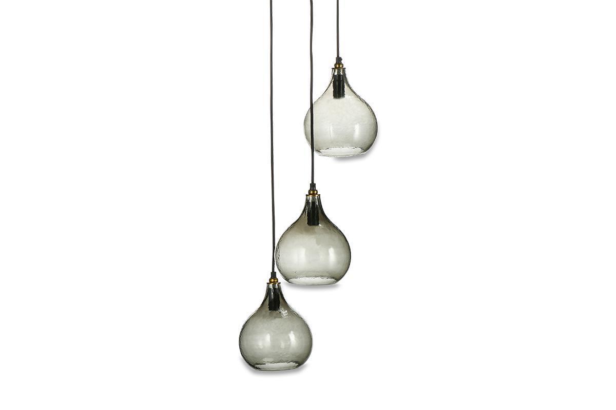 The nkuku Ziva Recycled Glass Cluster Pendant in Green Smoke features three adjustable modern glass lights with smoky teardrop shades and brass accents, hanging at different heights for a chic, contemporary look.